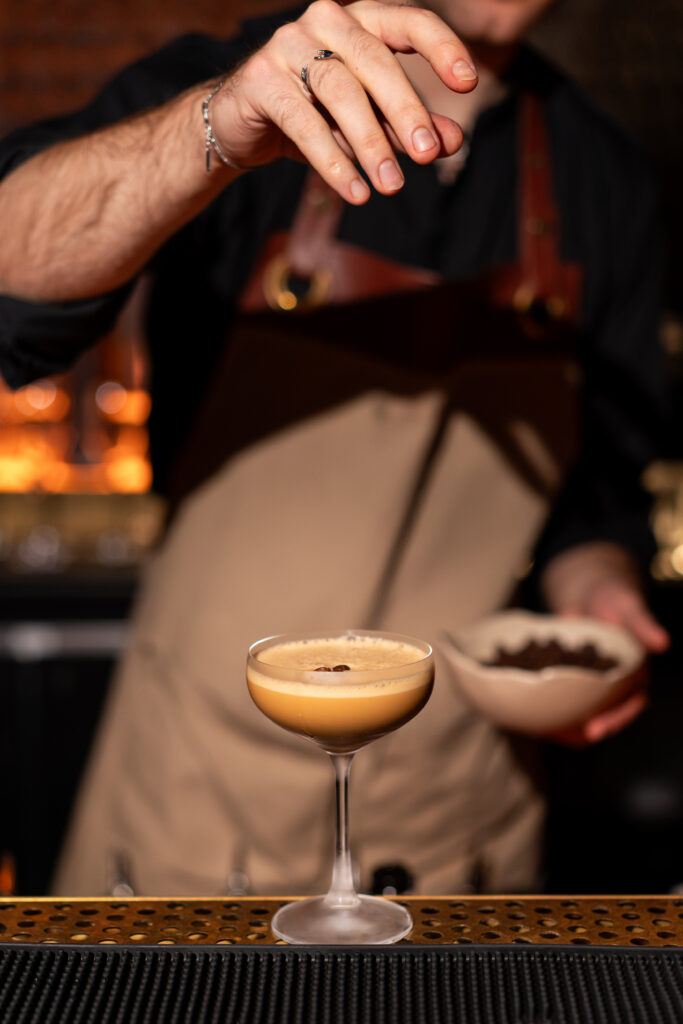 A bartender finishing a coffee cocktail with coffee beans at the WSTA GetTogether in Manchester
